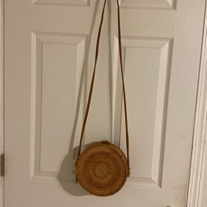 This round crossbody purse is has never been carried.  It has  a wicker look